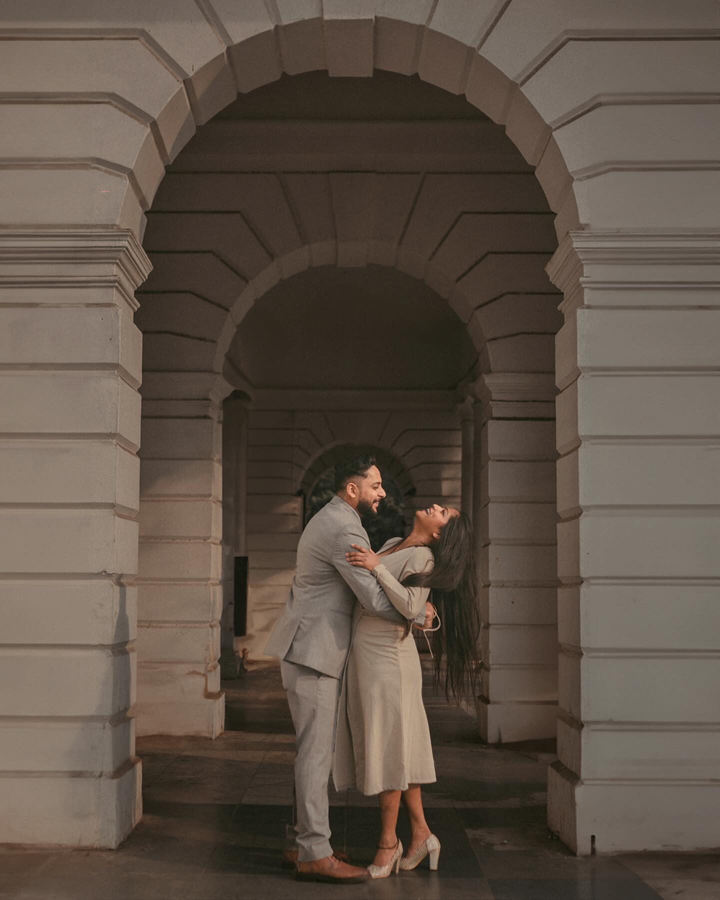Humayun tomb pre wedding shoot inspiration - couple embracing under cream stone arches, by 7thSky Productions