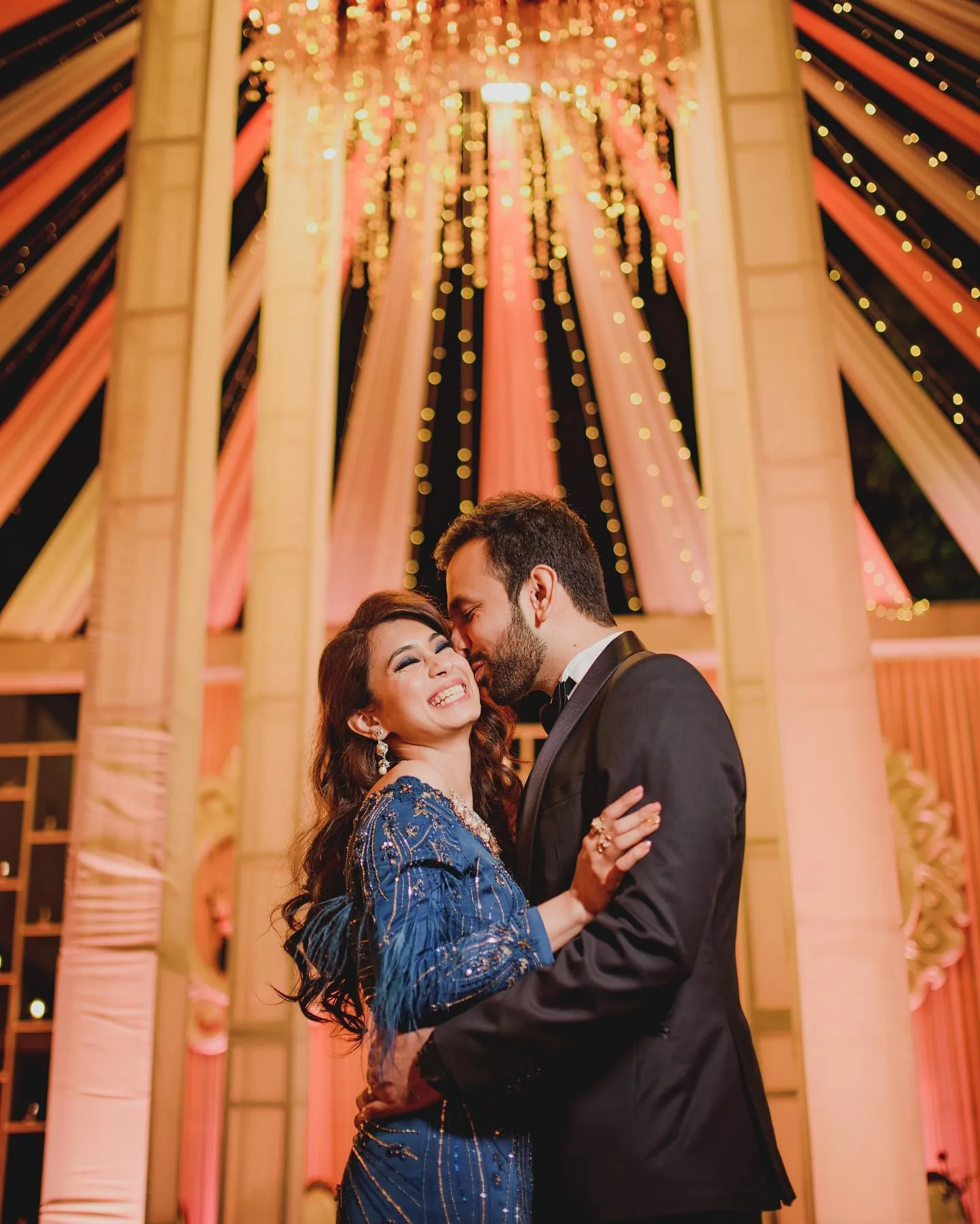 Candid wedding photographer Gurgaon - couple embracing under warm fairy lights, portfolio photo by Shaadi Photographers